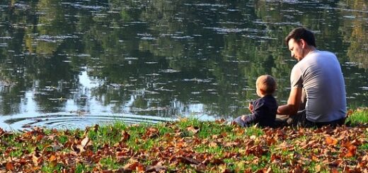 apa és gyermeke ül a folyóparton